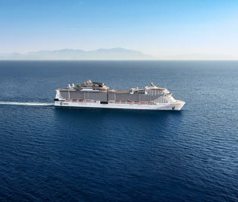 MSC Virtuosa dağlık kıyı açıklarında seyir halinde, yandan havadan görünüm