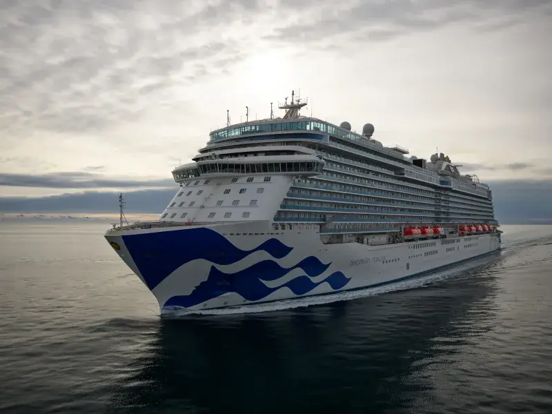 Discovery Princess'in açık denizde önden görünümü; pruvada Princess deniz kızı logosu