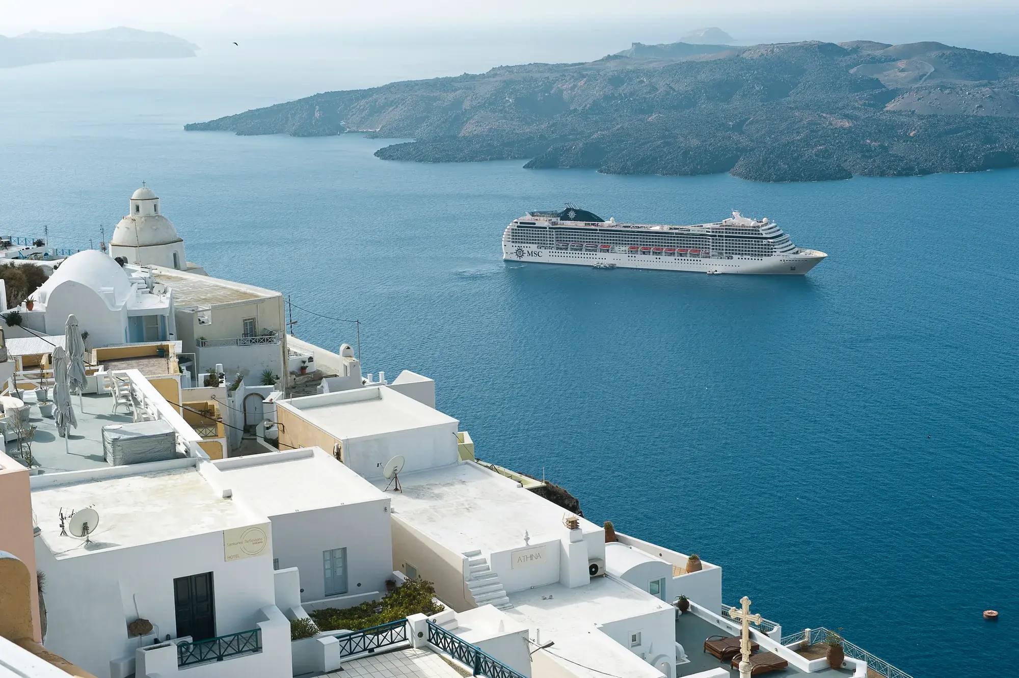 MSC Musica Santorini kalderasında demirli, beyaz evlerin arasından görünüm