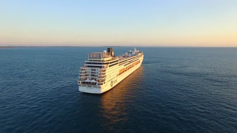 MSC Sinfonia gün batımında açık denizde, kıç taraftan uzaktan görünüm