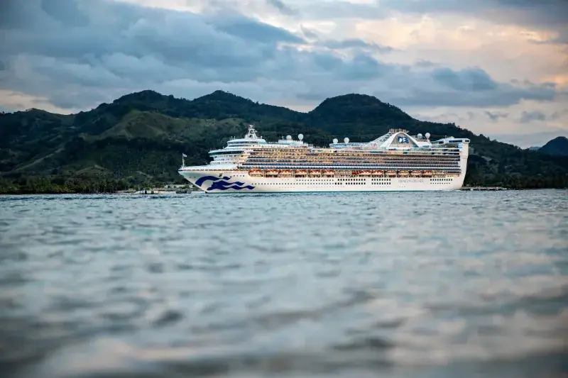 Caribbean Princess, Amber Cove (Dominik Cumhuriyeti) açıklarında; yeşil tepeler önünde yandan görünüm