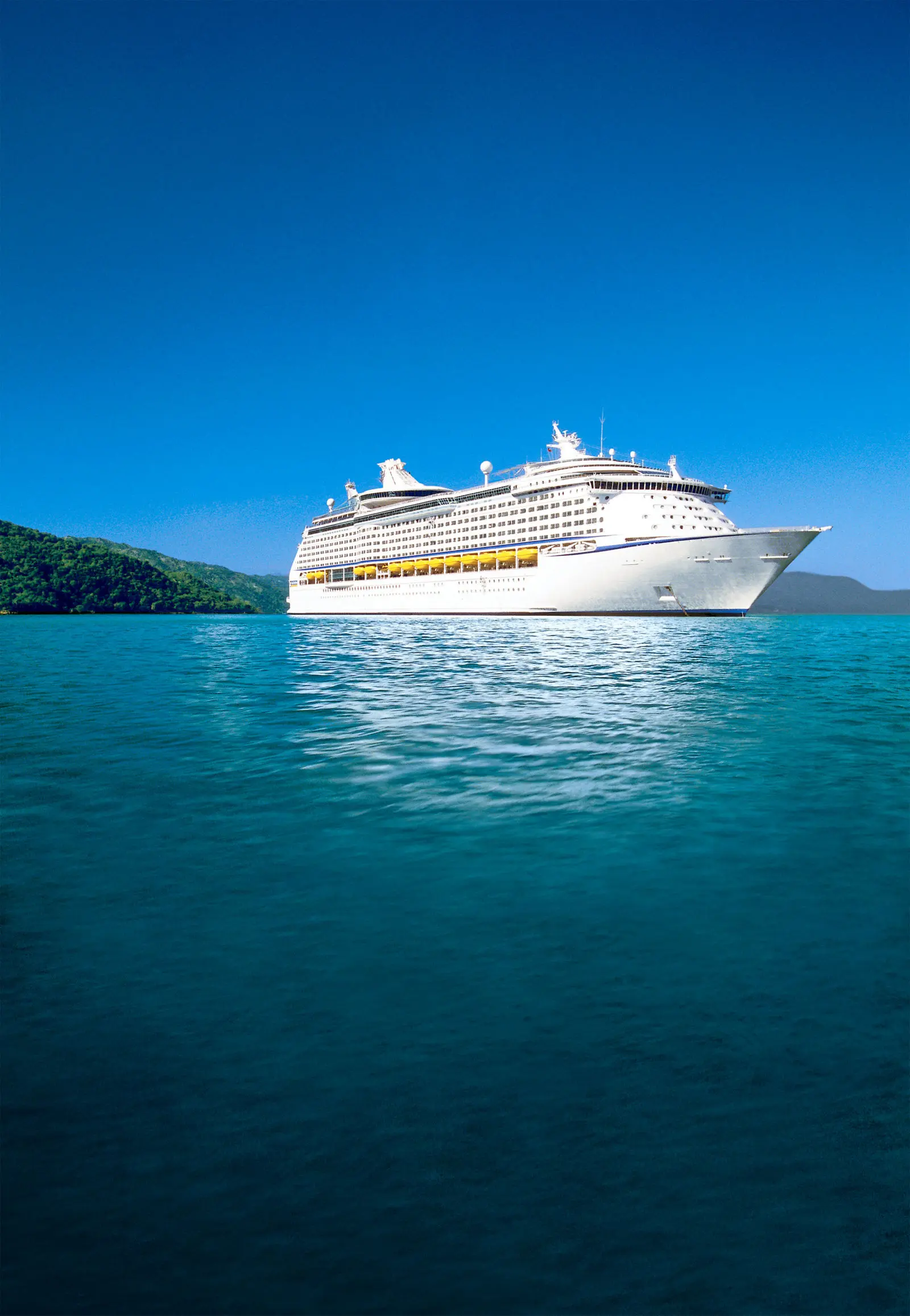 Adventure of the Seas açık denizde, arkada yeşil bir ada