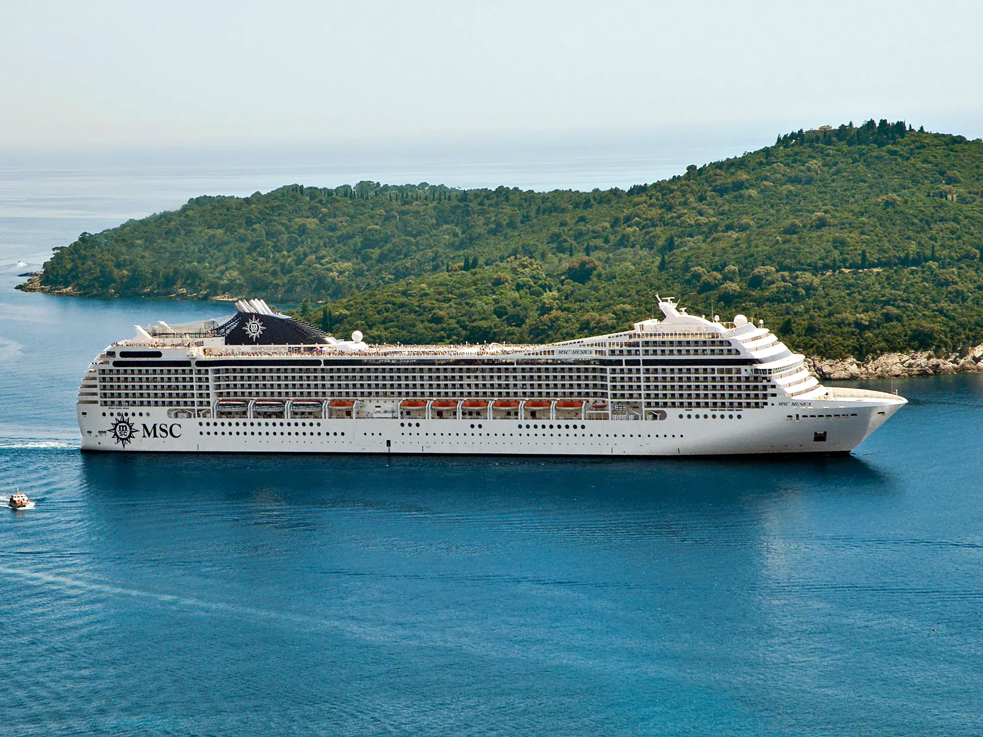 MSC Musica yeşil bir adanın önünde seyir halinde, yandan görünüm