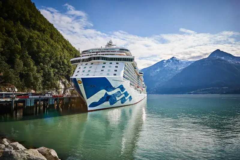 Royal Princess, Alaska'da Skagway iskelesinde; arkada karlı dağlar