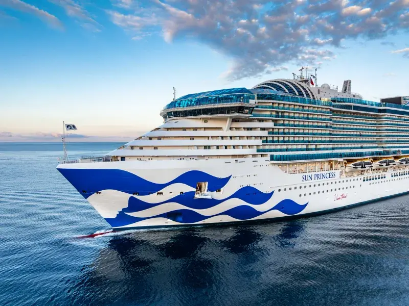 Sun Princess'in gün doğumunda önden görünümü; pruvada Princess deniz kızı logosu