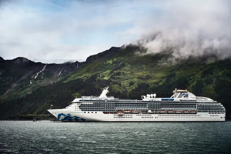 Island Princess yeşil dağlar önünde demirli
