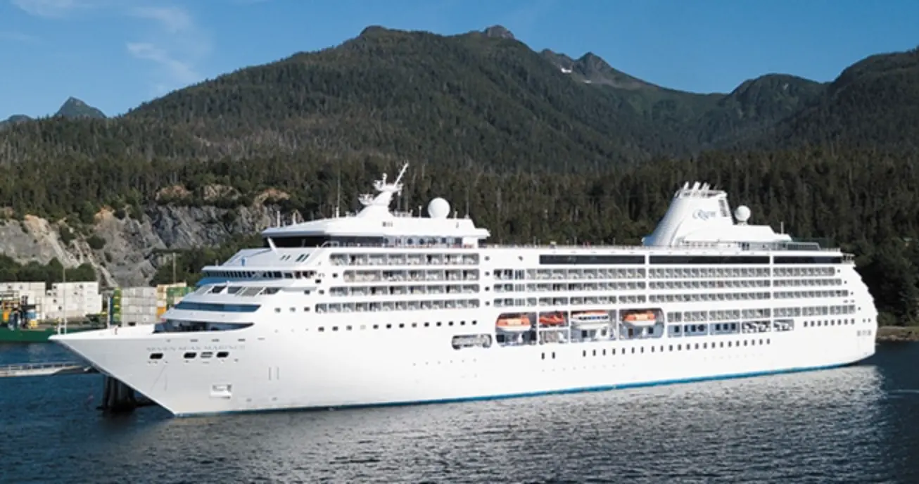 Seven Seas Mariner ormanlık dağların önünde limanda