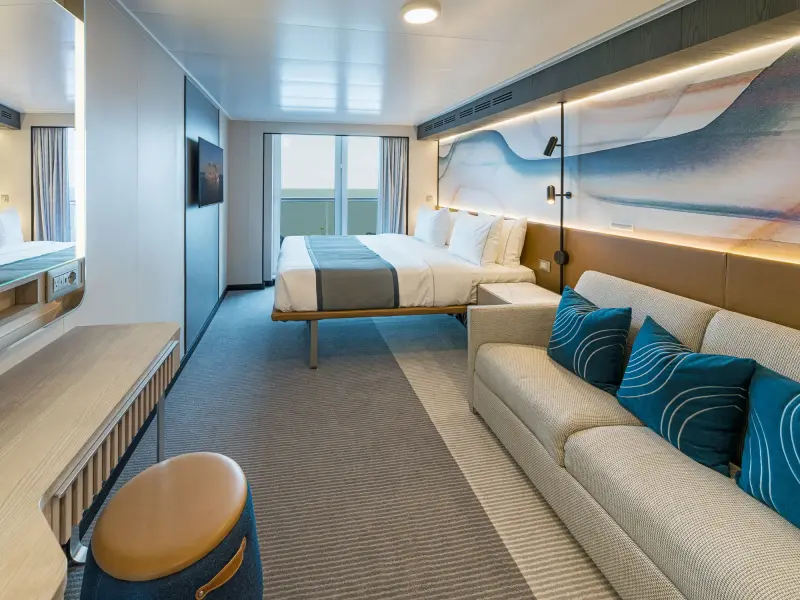 Norwegian Aqua, Norwegian Aura ve Norwegian Bella'da balkonlu kabin; çift kişilik yatak, kanepe ve balkon kapısı