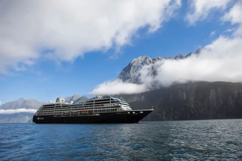 Azamara Journey Milford Sound'da, bulutlu dağlar önünde